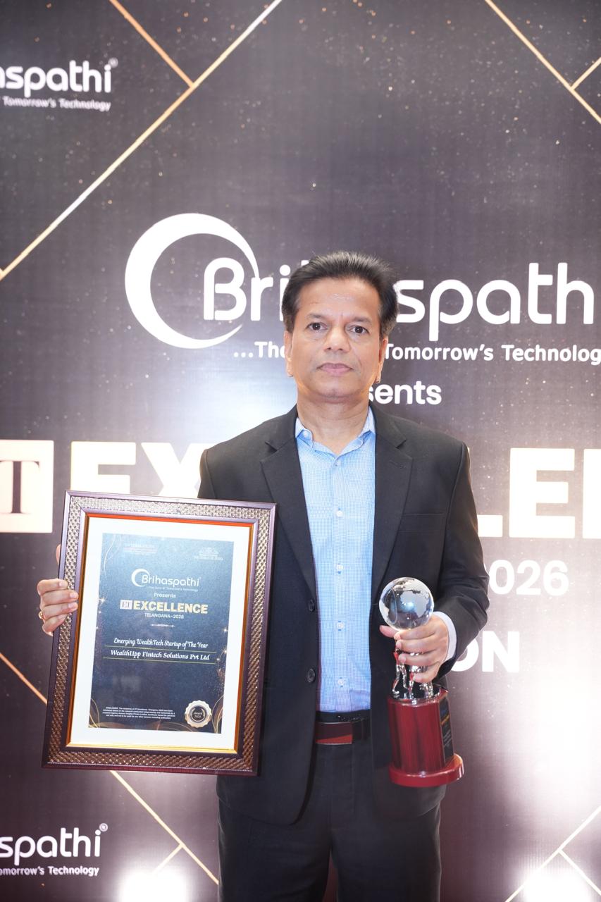 Ram Tulluri holding the ET Excellence citation plaque and crystal trophy on stage